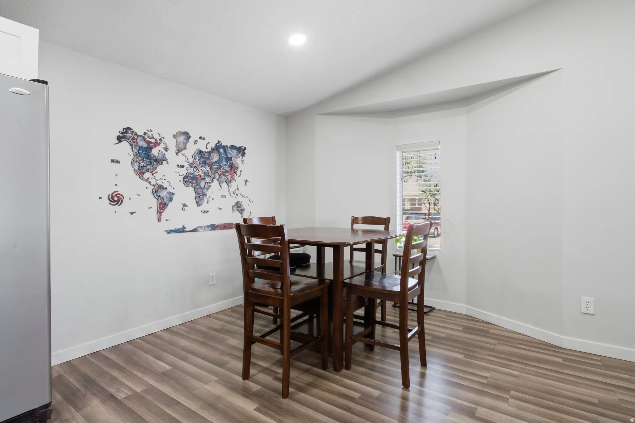 Recessed lighting, wood-finish flooring, and a window with blinds