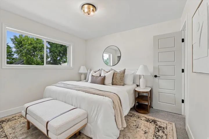Recessed window with white trim, flush mount ceiling light fixture, five-panel interior door with matte black hardware