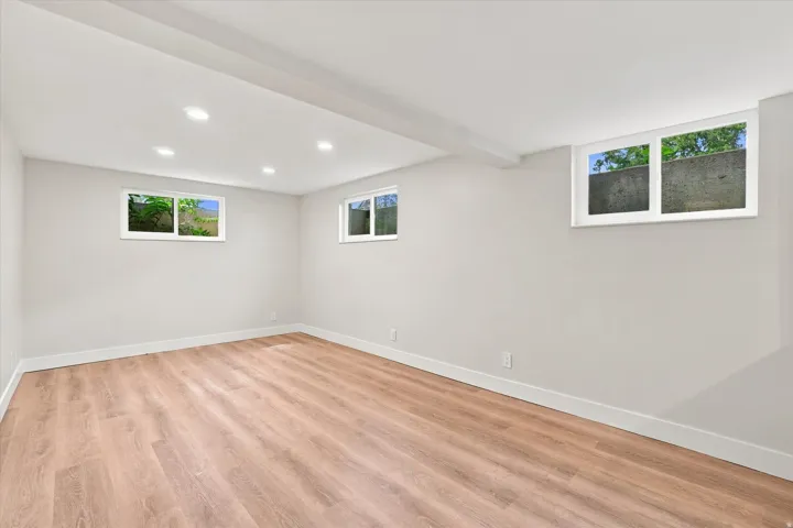 ADU has Spacious room featuring wood-finish flooring, recessed lighting, and multiple windows
