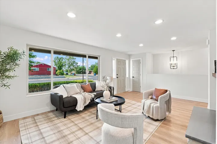 Wood-finish flooring, recessed lighting, expansive window, paneled entry doors, and a modern chandelier