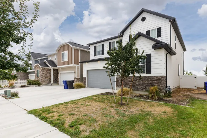 Contemporary exterior with white siding, dark shutters, a dark roof, and a stone facade