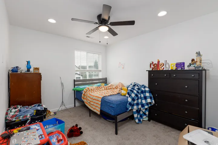 Recessed ceiling lighting with a ceiling fan, window with blinds, and neutral wall color