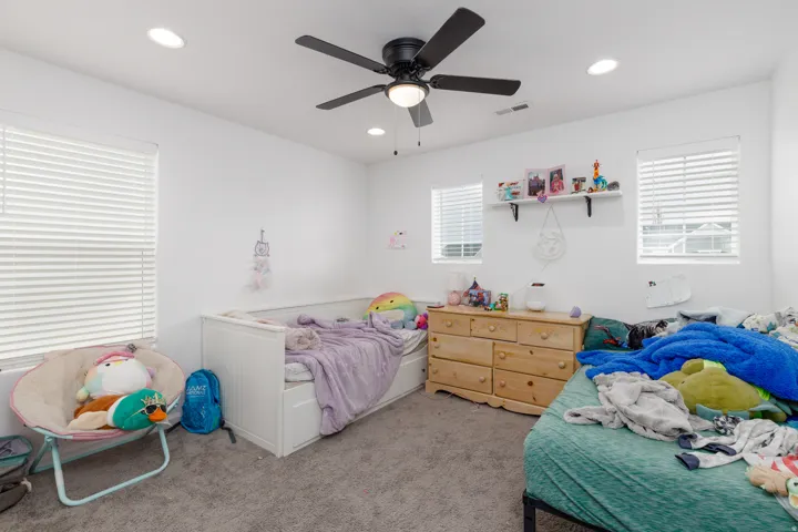 White walls, recessed lighting, and a dark ceiling fan with integrated light
