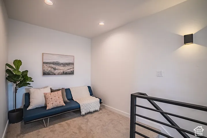 Recessed ceiling lighting, wall-mounted sconce lighting, and black metal railing