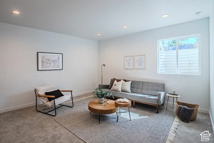 Recessed ceiling lighting, light-toned wall finishes, a window with horizontal blinds, and carpeting
