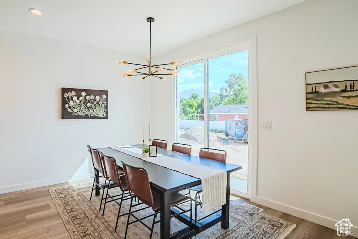 Recessed ceiling lighting, modern chandelier, wood-finish flooring, sliding glass door, white trim