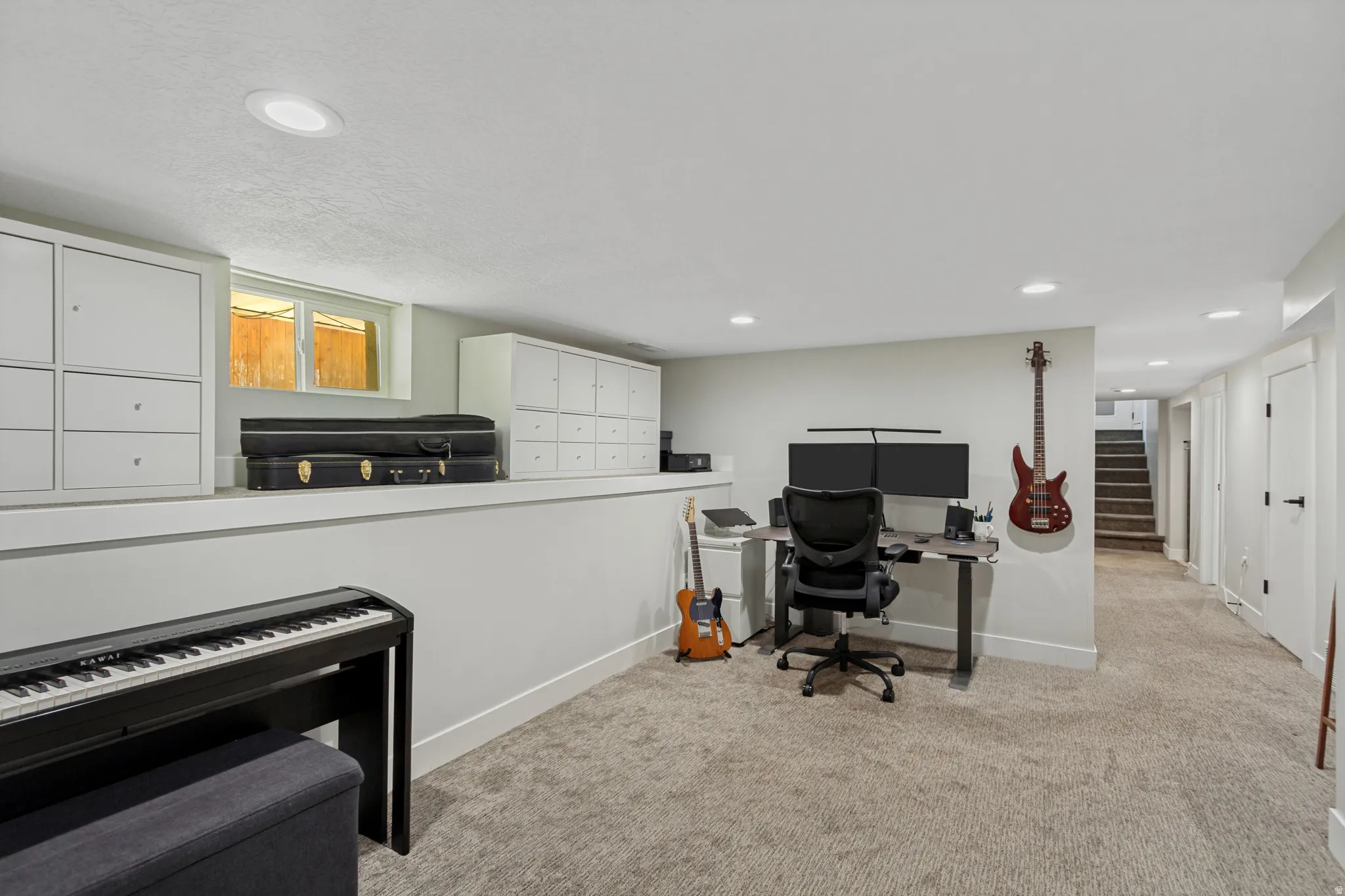 Carpeted room with recessed lighting, built-in cabinetry, and a window