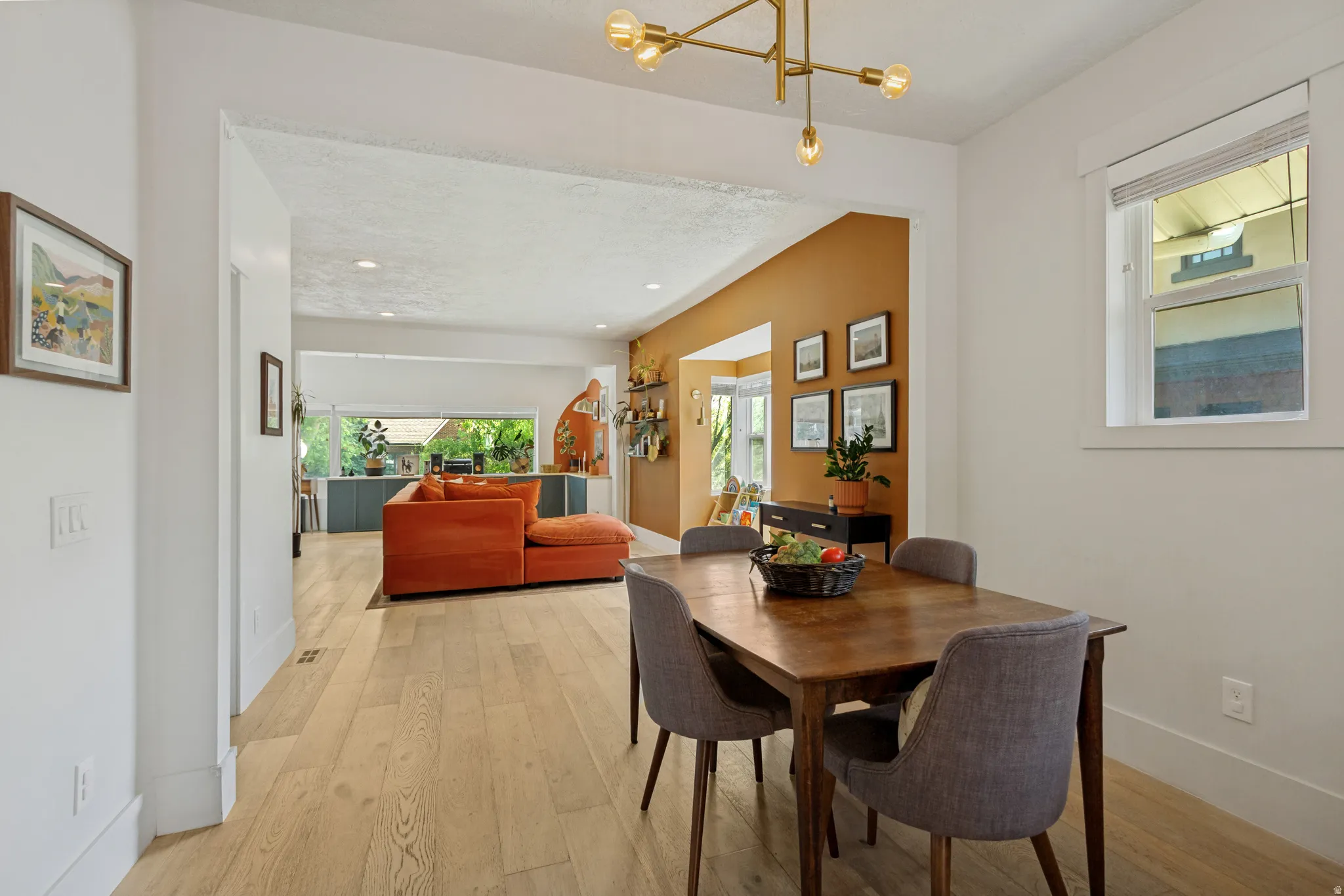 Open concept layout featuring wood-finish flooring, a contemporary chandelier, and recessed lighting