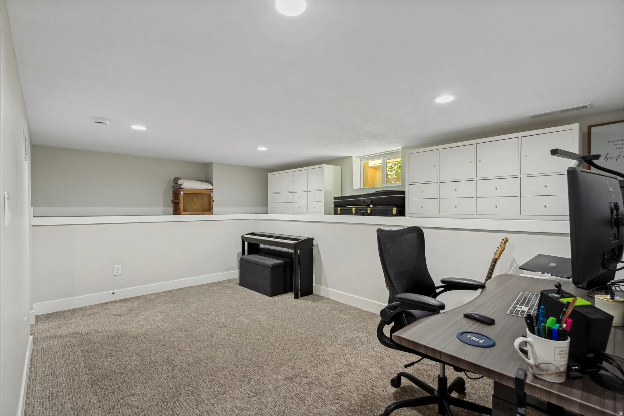 Recessed lighting, light gray carpeting, built-in white cabinetry, and a window with natural light
