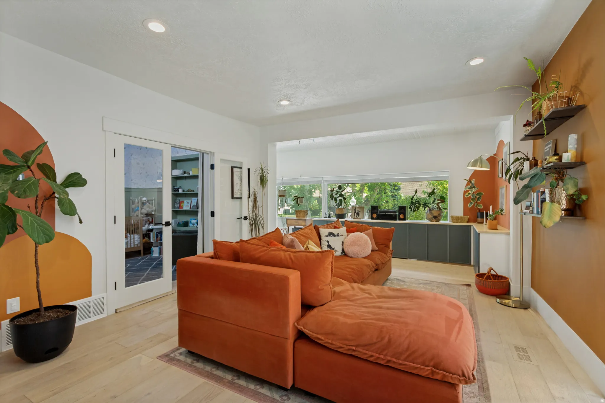 Recessed lighting, wood-finish flooring, white trim, built-in shelving, and French doors with frosted glass