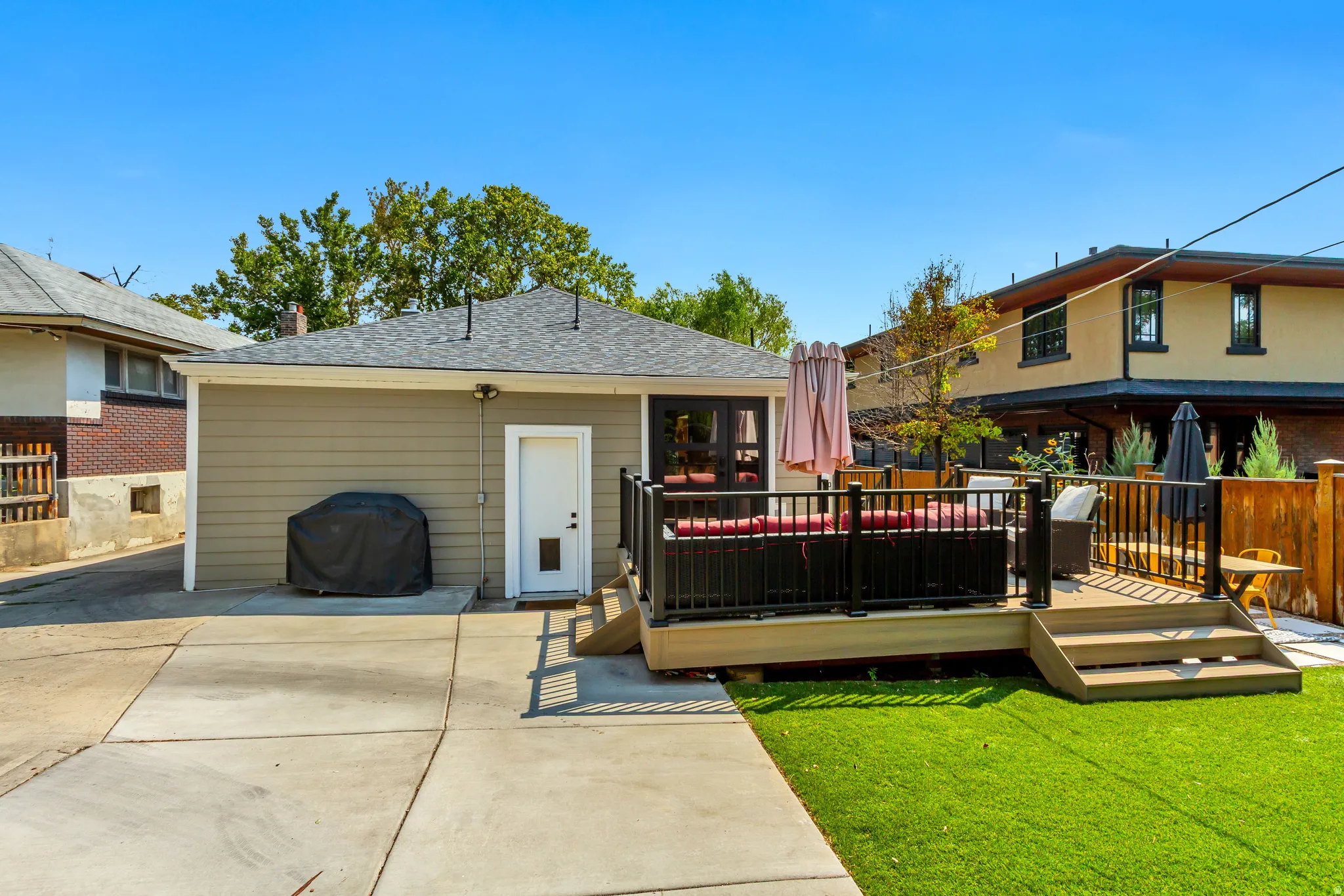 Outdoor deck with steps, black railings, and wood-finish flooring
