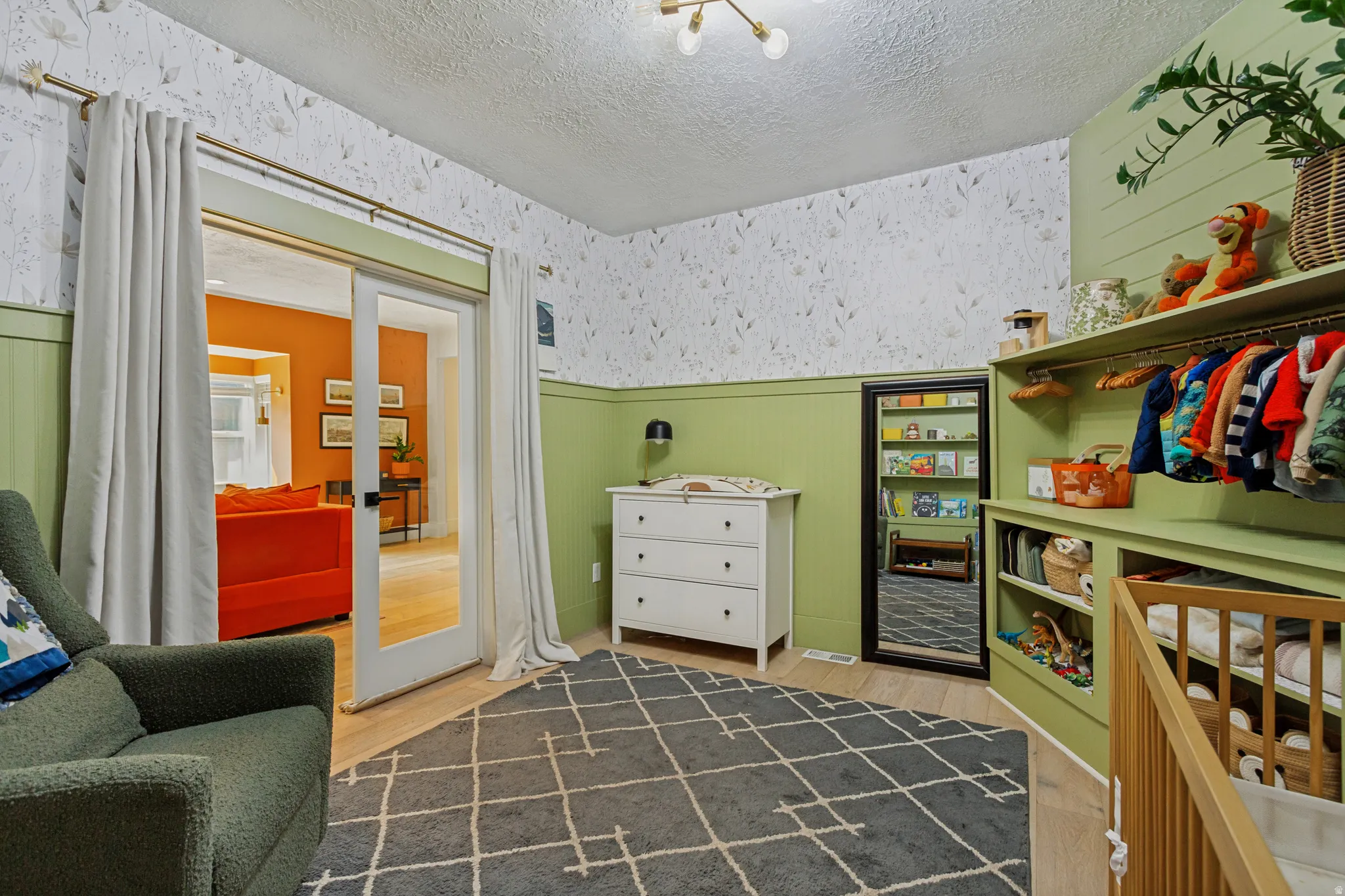 White paneling with botanical-patterned wallpaper