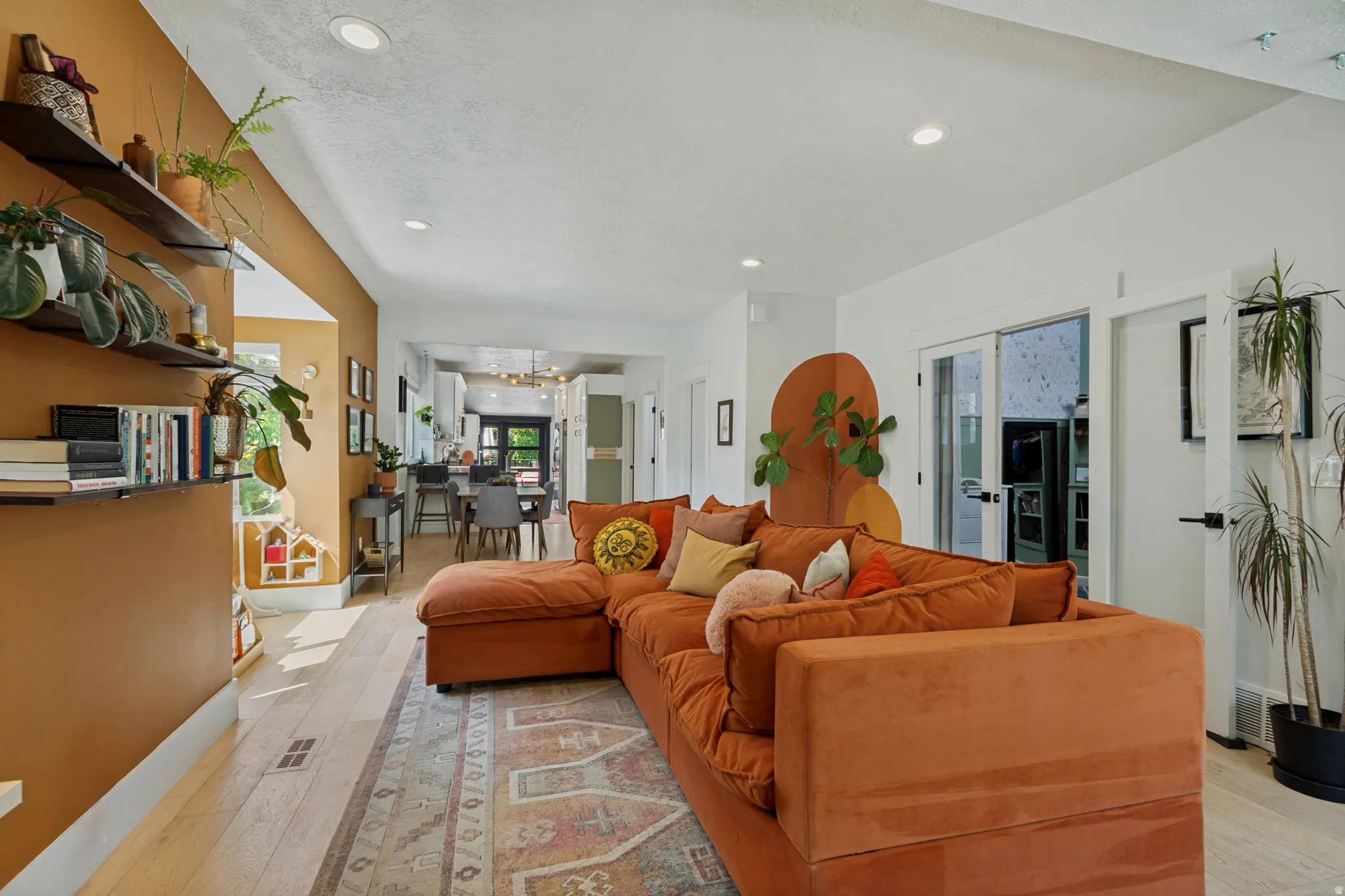 Recessed lighting illuminates the open-concept living space with wood-finish flooring
