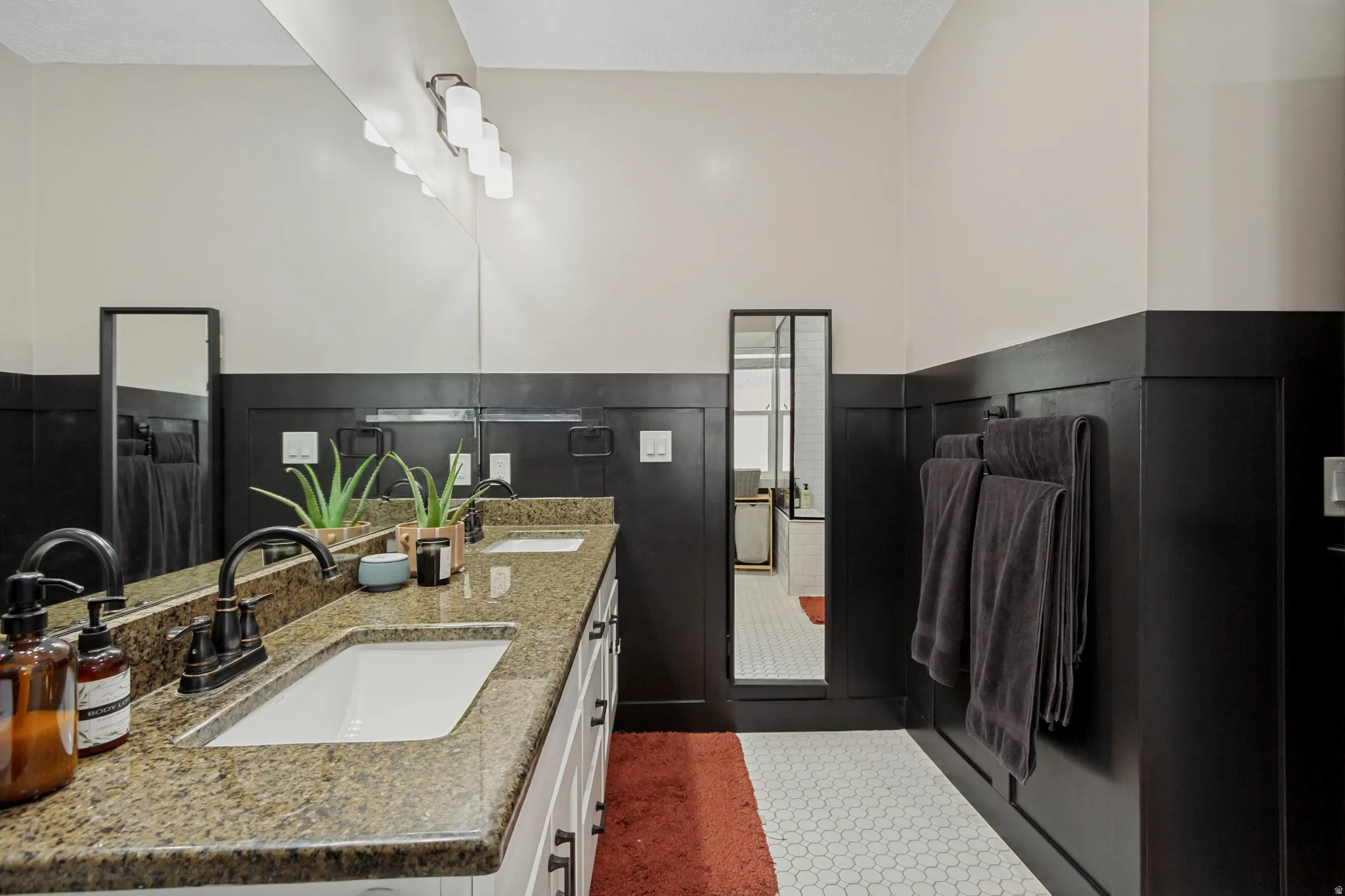 Dual vanity with white undermount sinks and speckled stone countertops