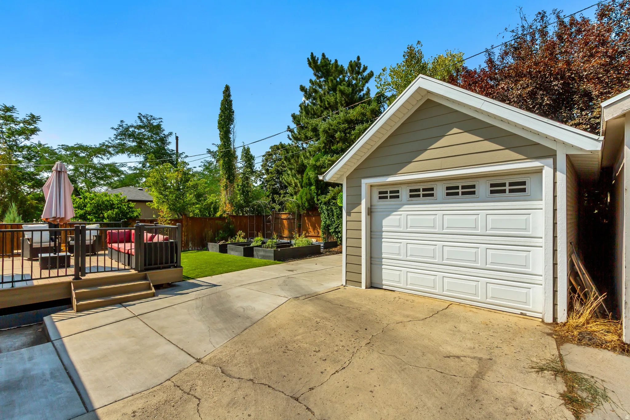 Detached garage with horizontal siding, a paneled garage door, and upper-level windows