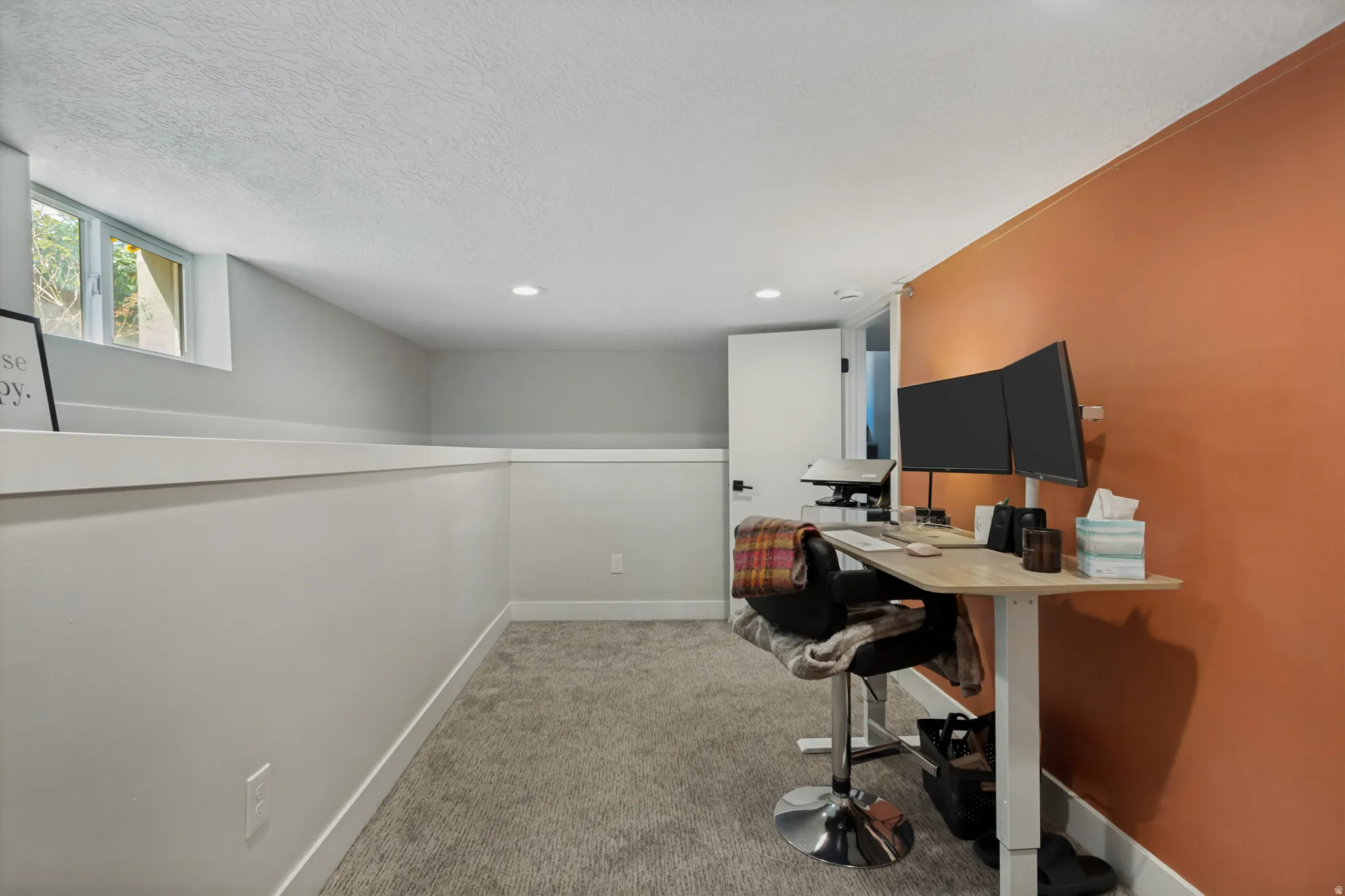 Recessed lighting, carpet flooring, a single window, and a white door with black hardware