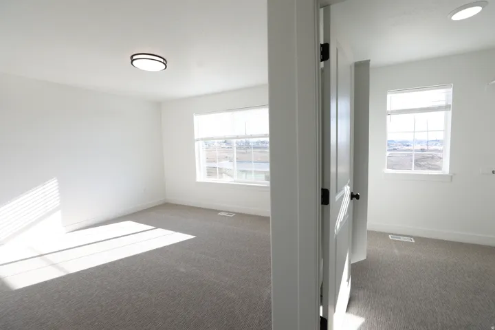 Wall-to-wall carpeting with multiple windows, recessed ceiling lighting, and a modern flush mount light fixture