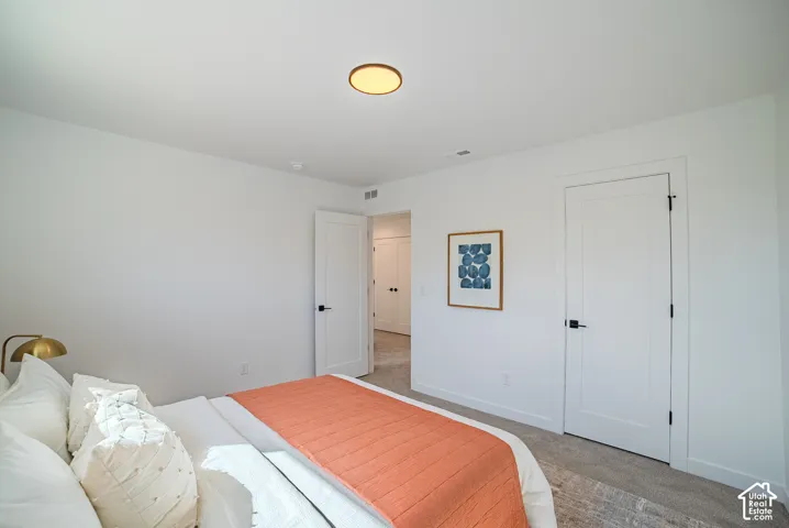 Recessed lighting, light gray carpet flooring, matte black door hardware, white interior doors, and a flush-mount ceiling light fixture