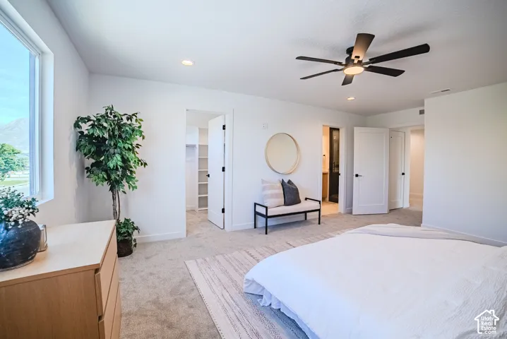 Recessed lighting, ceiling fan, white paneled doors with black hardware, and carpet flooring