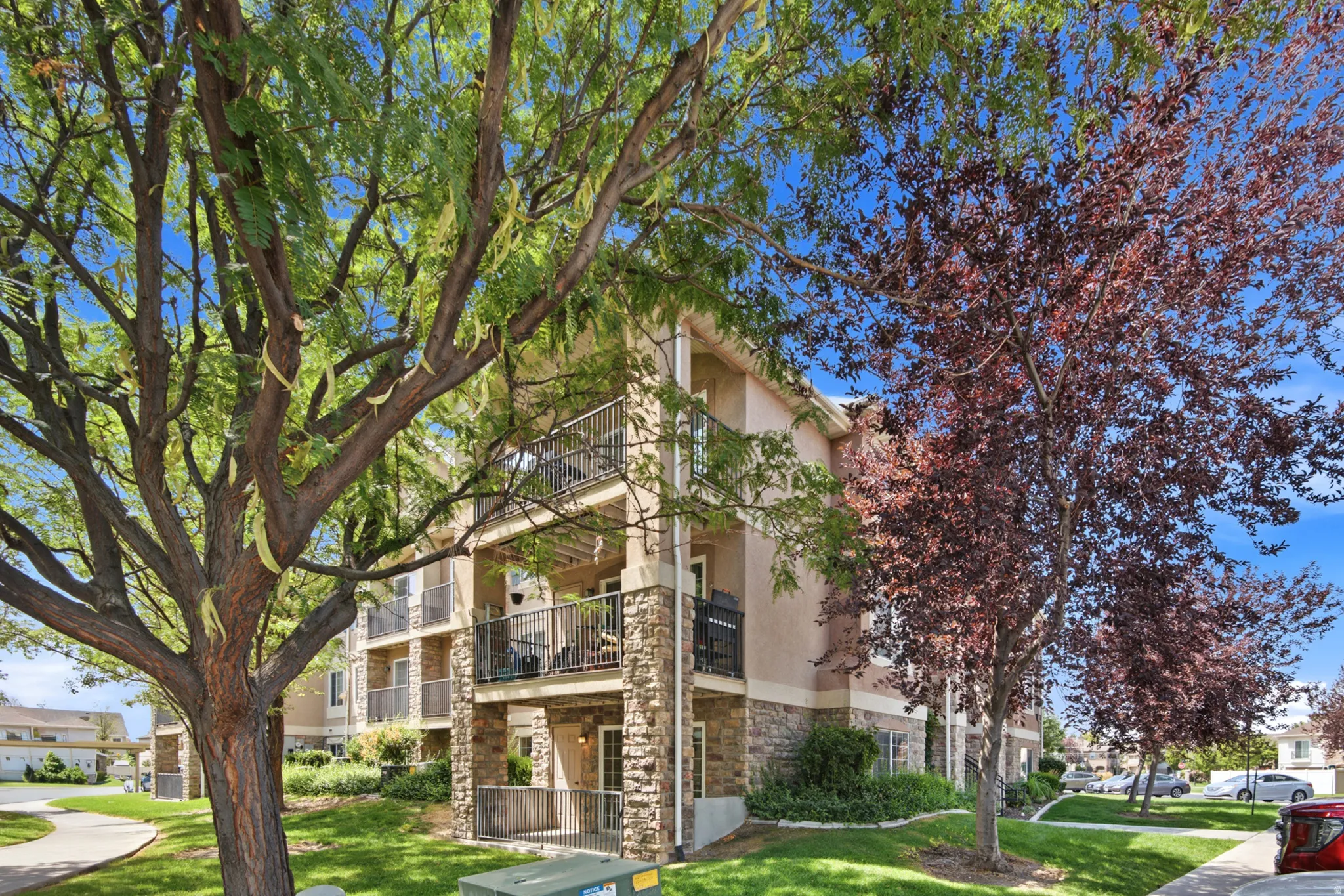 Multi-story residential building with stone facade accents and stucco siding
