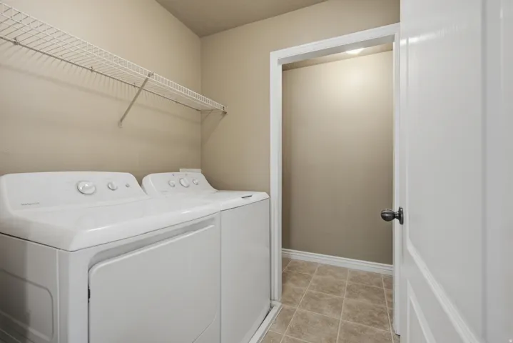 Wire shelving, neutral wall paint, white trim, and tiled flooring