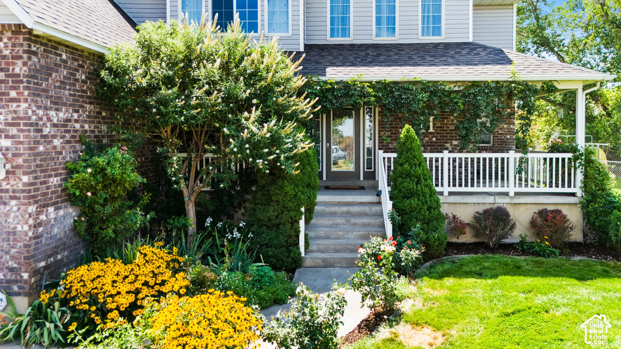 Brick and siding exterior with a covered front porch featuring white railings