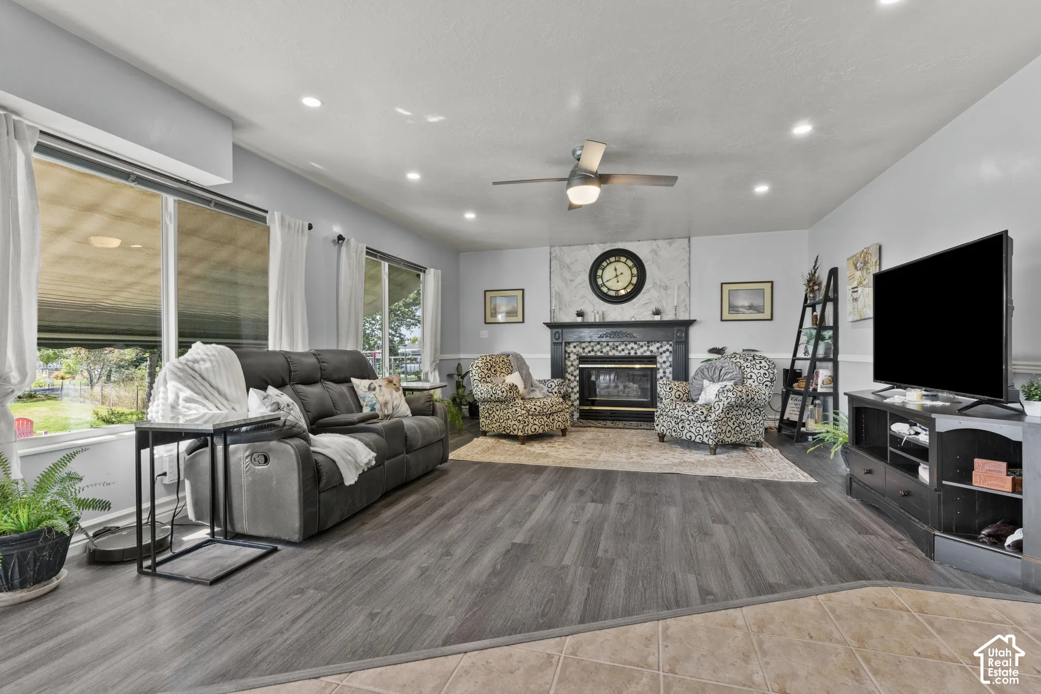 Spacious living area featuring wood-finish flooring, a fireplace with a decorative mantel and tile surround, and recessed lighting
