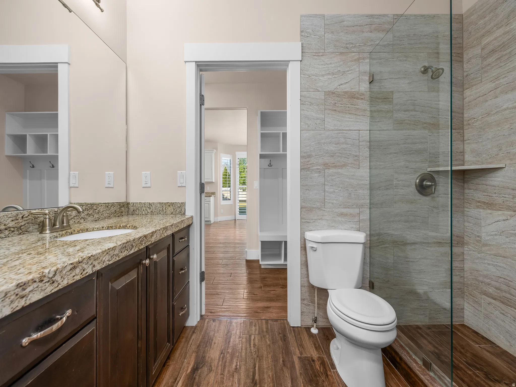 Walk-in shower with tile surround, glass enclosure, and integrated shelf