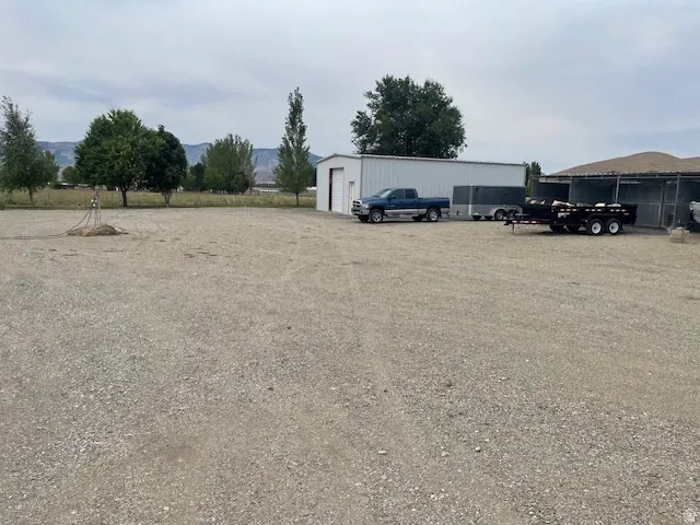 Gravel lot featuring a metal-sided building with a roll-up door