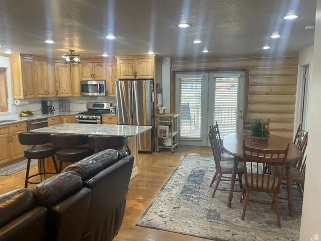 Kitchen featuring wood cabinetry, stainless steel appliances, a center island with seating, and recessed lighting