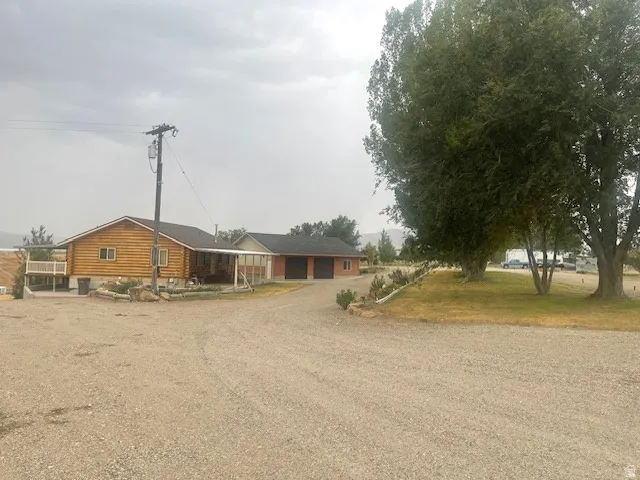 Log cabin style residence with a gravel driveway and an attached two-car garage