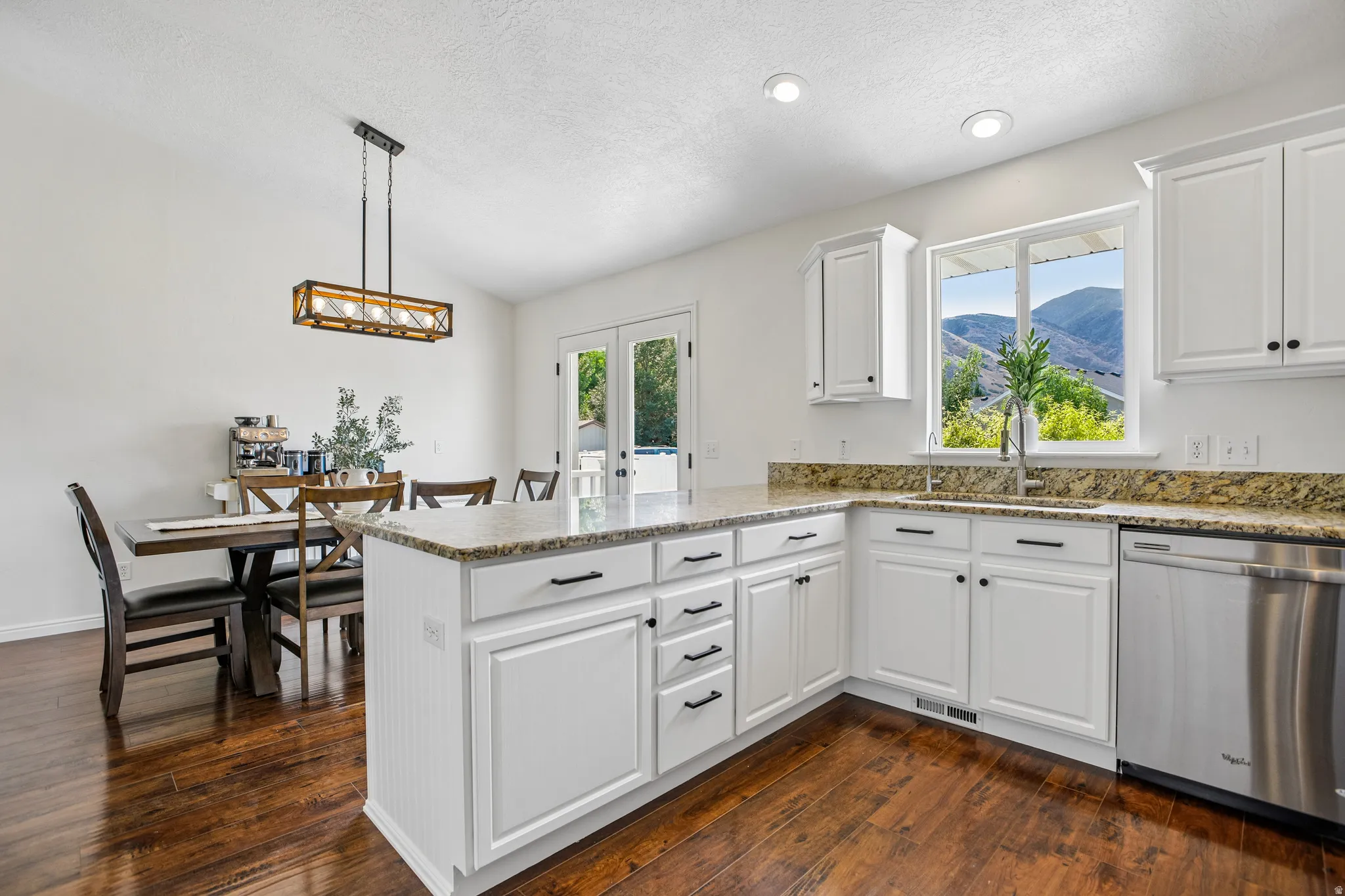 Kitchen featuring white cabinetry, a center island with countertop seating, wood-finish flooring, recessed lighting, and stainless steel appliances