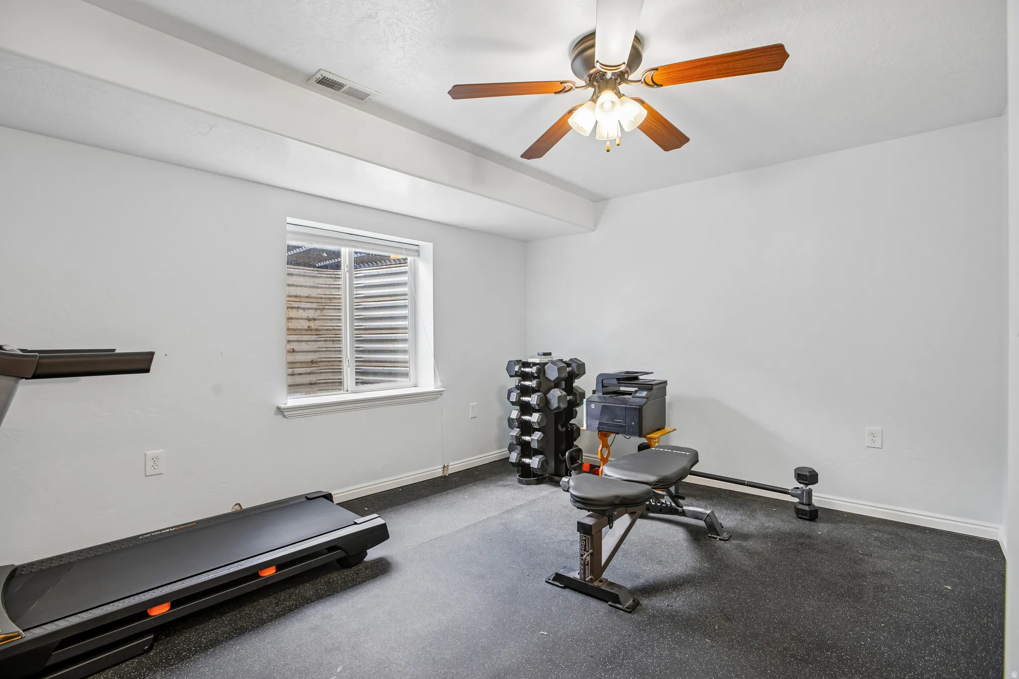 Recessed window with white trim, ceiling fan with wood-tone blades, white walls, and a durable floor surface