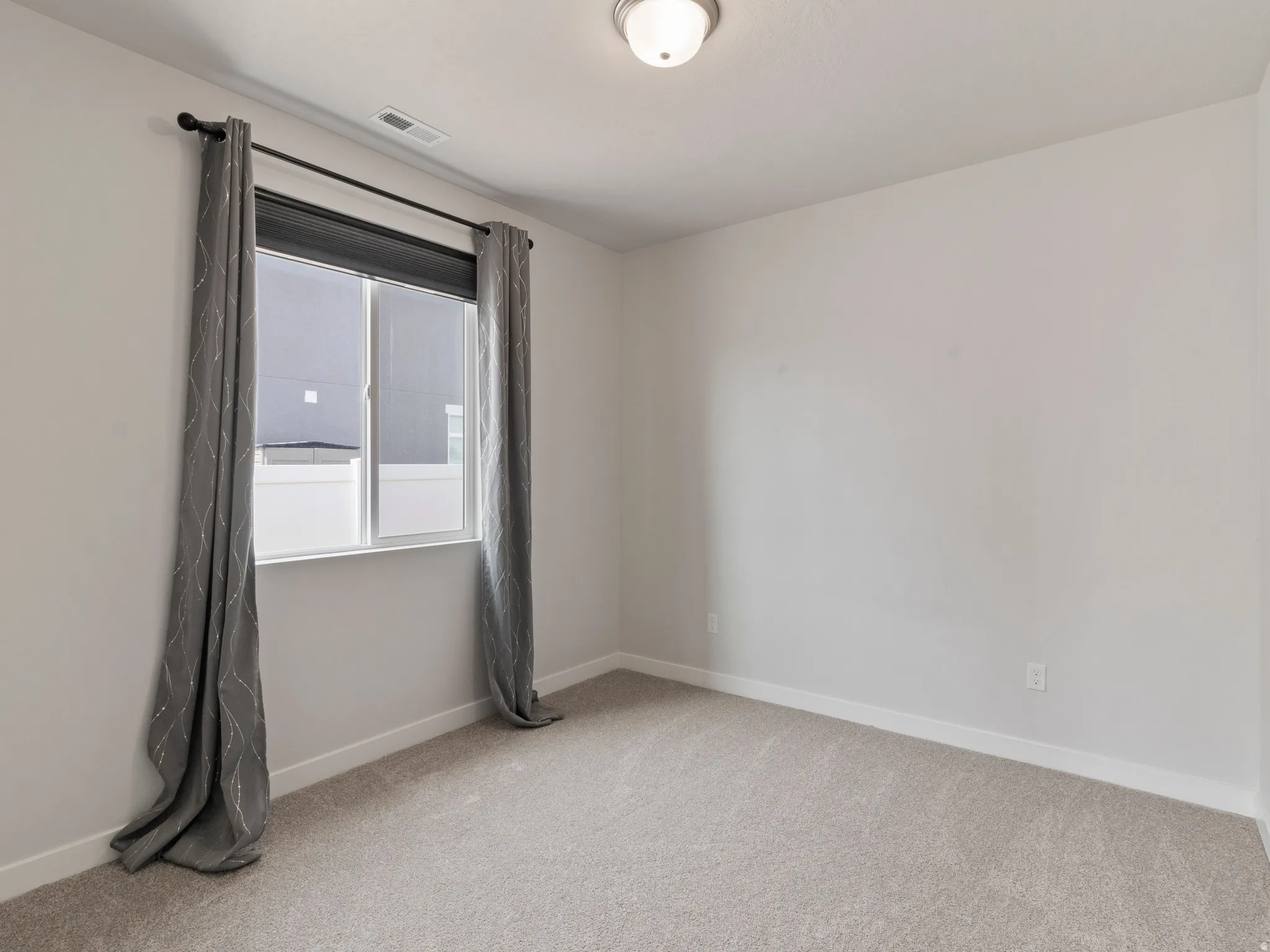 Neutral-toned walls complement the light-colored carpet flooring