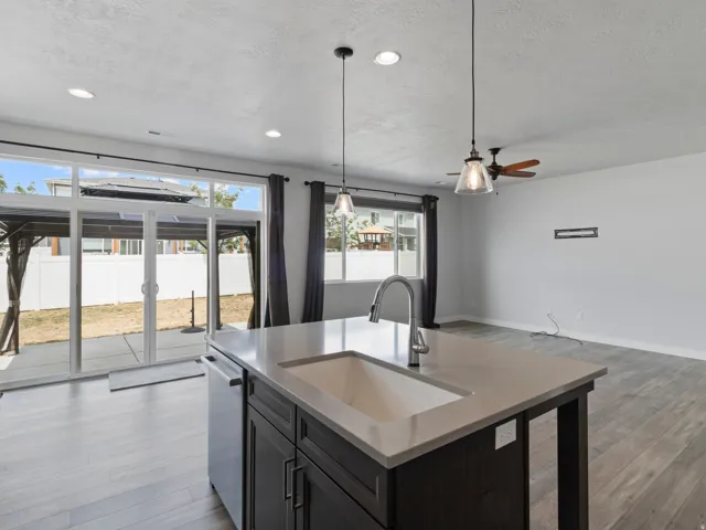 Kitchen island with an undermount sink, gooseneck faucet, and light-toned countertop
