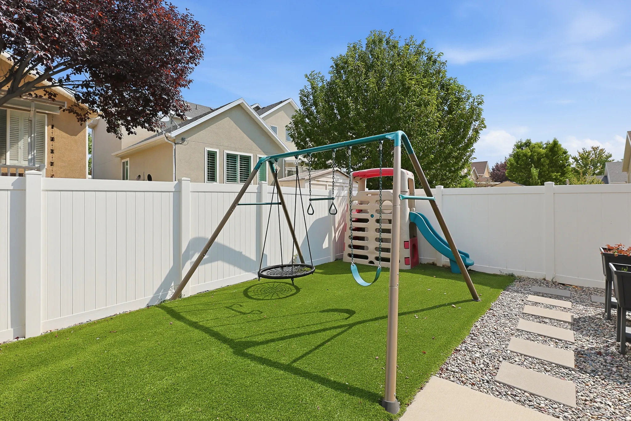 Synthetic lawn and a gravel pathway with concrete stepping stones