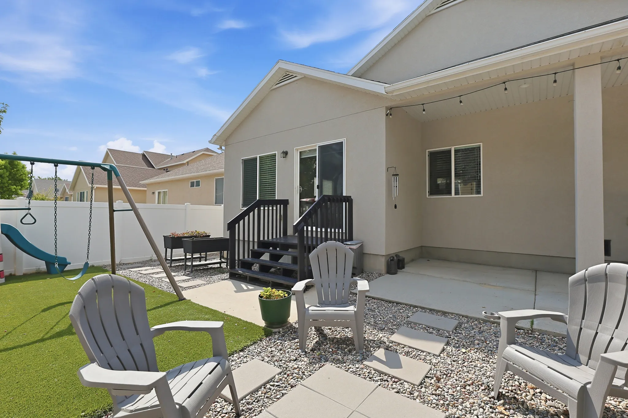 Stone patio with gravel landscaping, and a covered deck