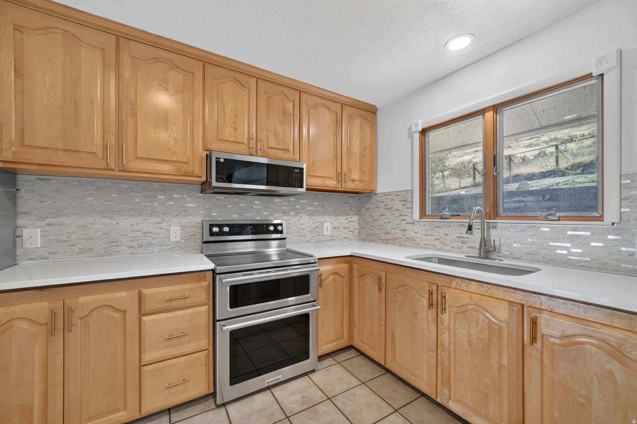 Kitchen featuring new paint, new backsplash, new quartz countertops and a new microwave. *Refrigerator, Stove, Microwave, Dishwasher all included.