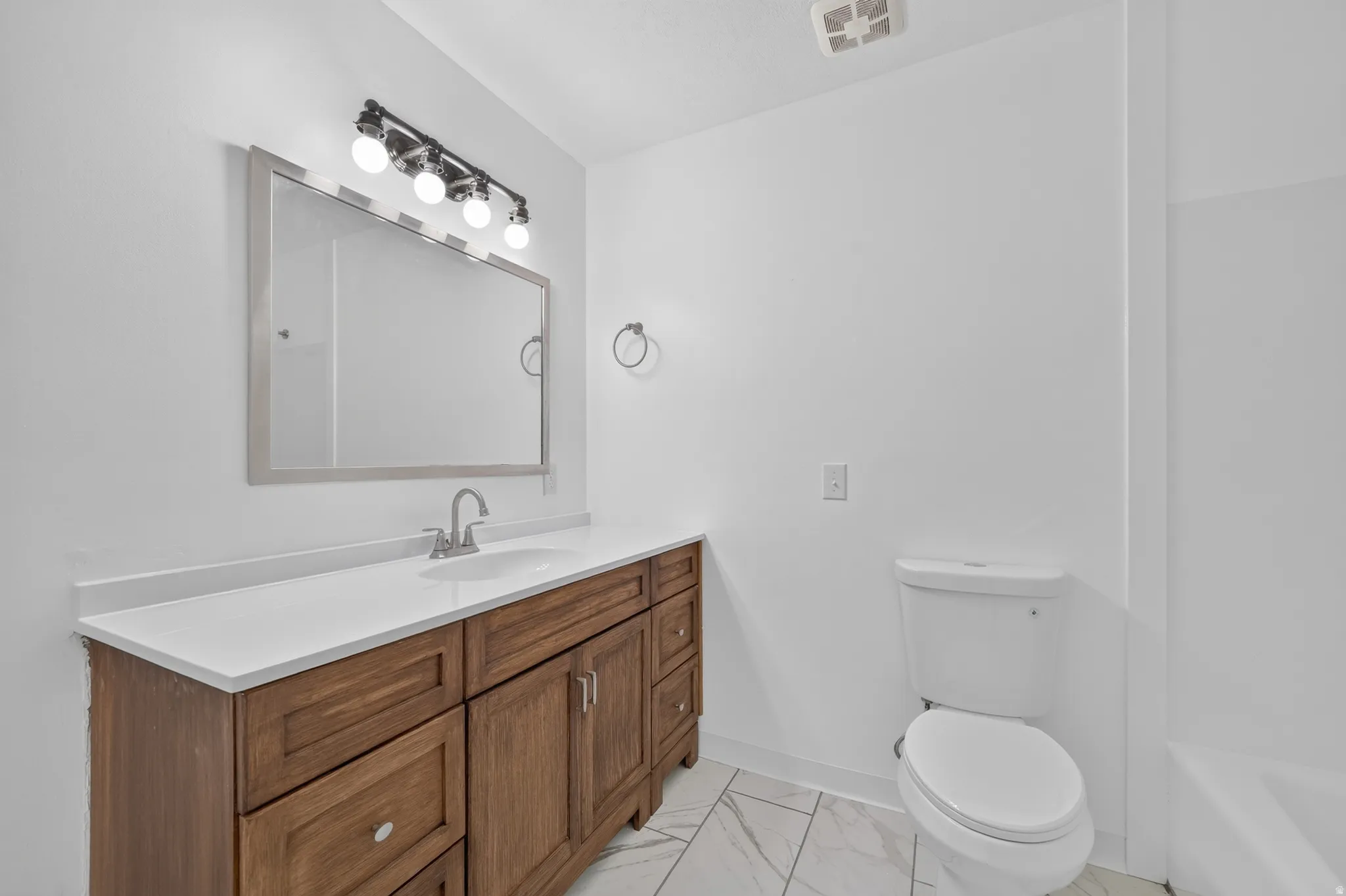 Main hall bathroom featuring a new refresh with new flooring, paint, vanity and countertop
