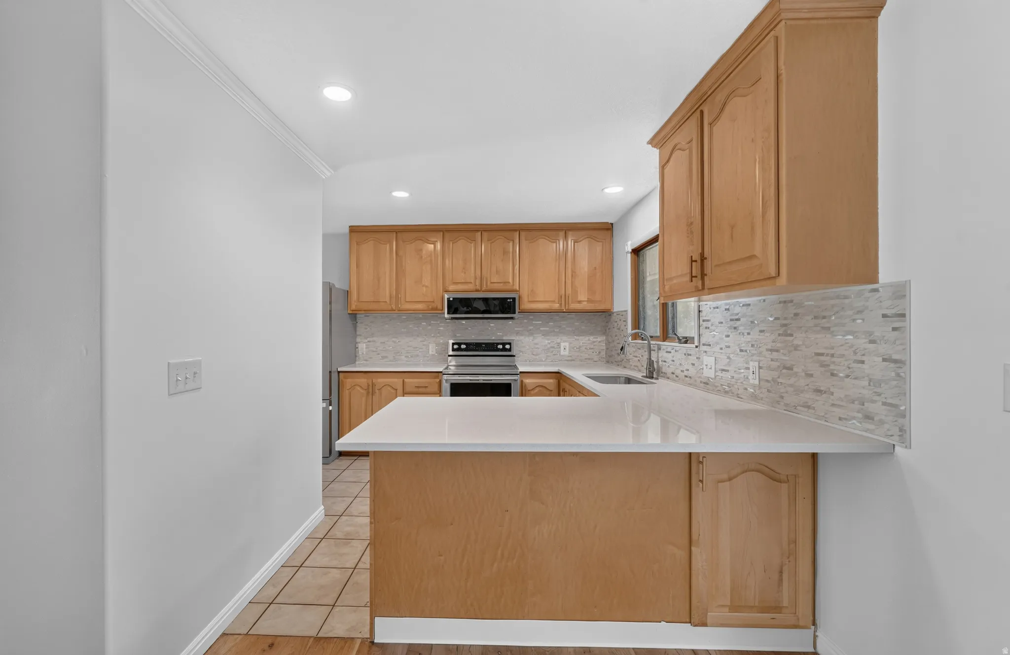 Kitchen featuring new paint, new backsplash, new quartz countertops and a new microwave. *Refrigerator, Stove, Microwave, Dishwasher all included.