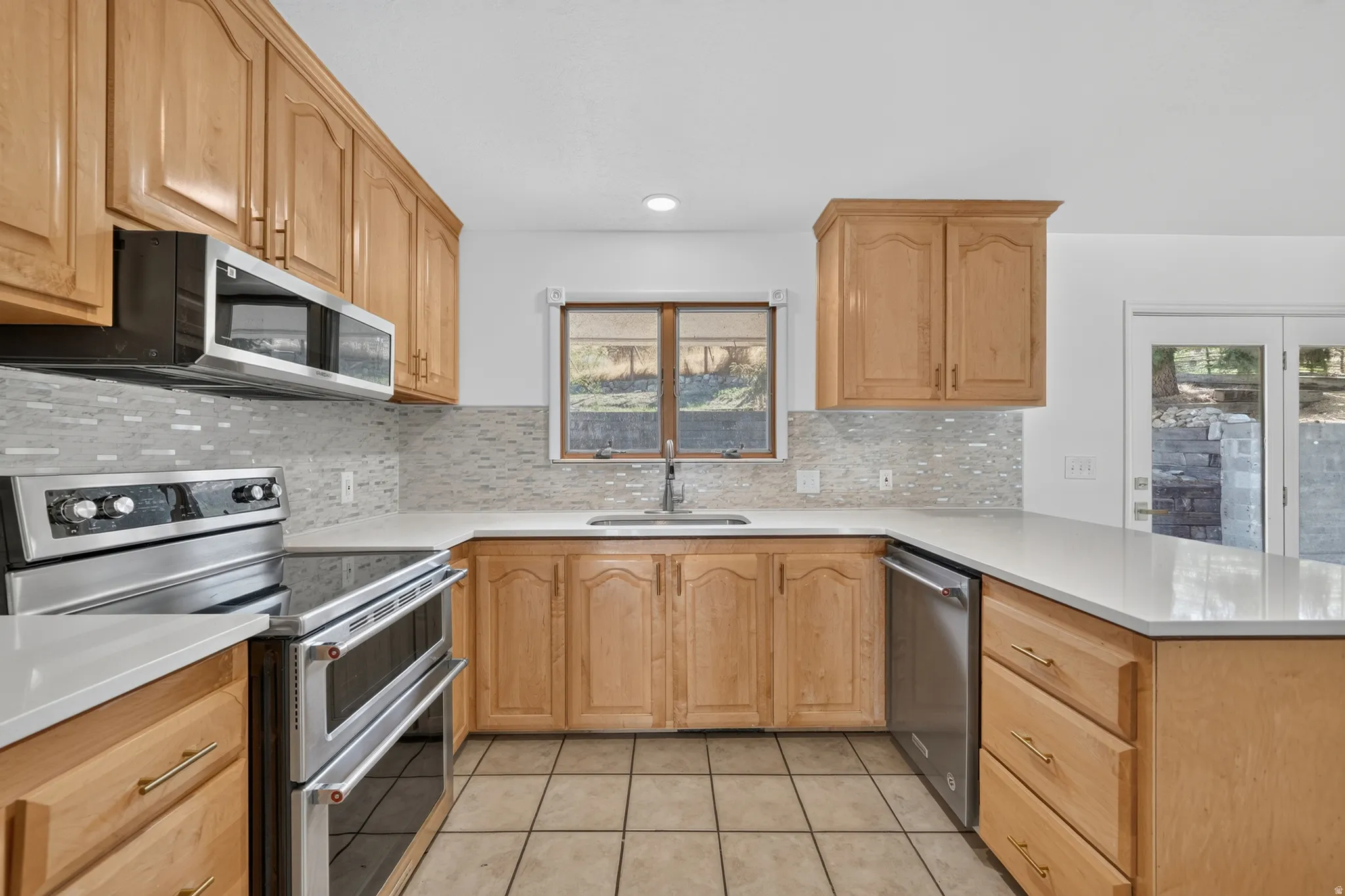 Kitchen featuring new paint, new backsplash, new quartz countertops and a new microwave. *Refrigerator, Stove, Microwave, Dishwasher all included.