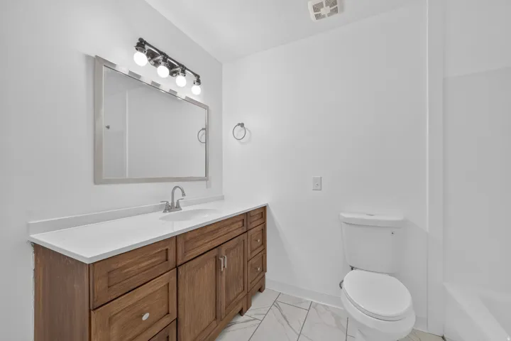 Main hall bathroom featuring a new refresh with new flooring, paint, vanity and countertop