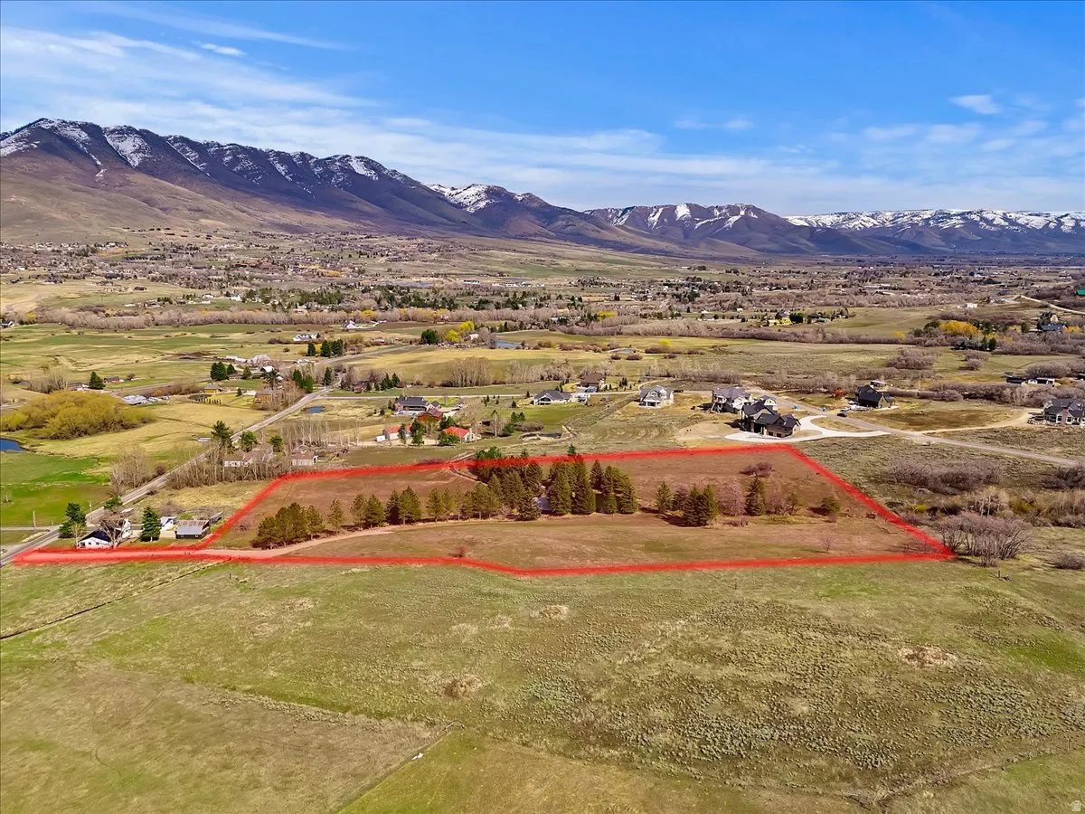 Expansive undeveloped land with a prominent mountain backdrop and mature trees