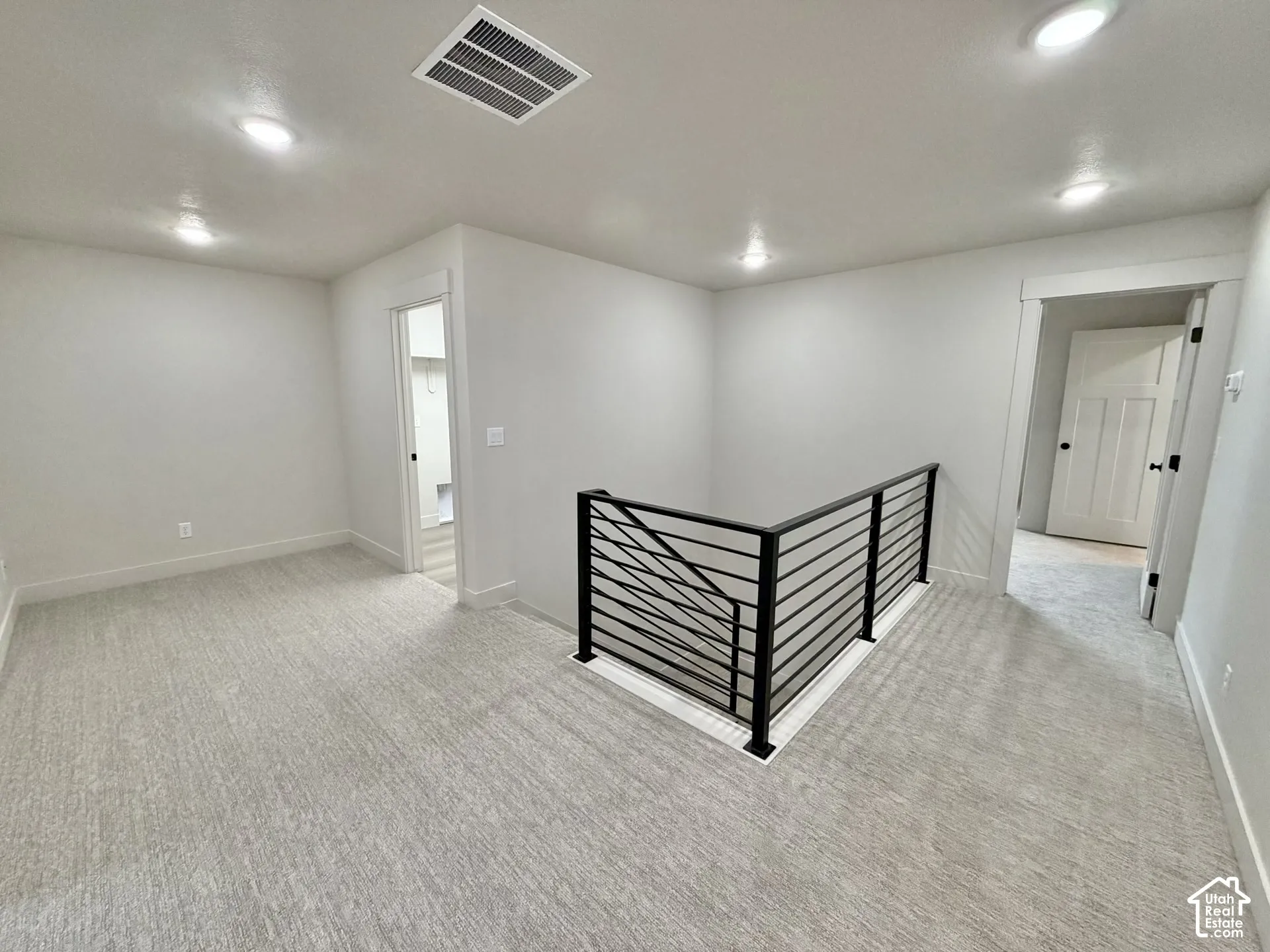 Interior area featuring recessed lighting, wall-to-wall carpeting, and a black metal horizontal-bar railing