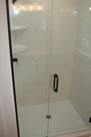 Walk-in shower with clear glass enclosure and black frame