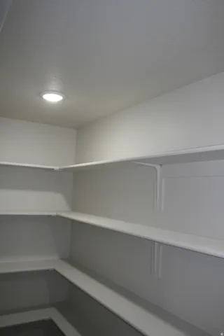 Recessed ceiling lighting illuminates white walls and built-in shelving