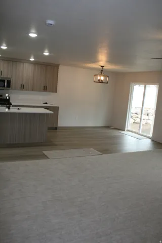 Kitchen featuring wood-finish cabinetry, stainless steel appliances, and a central island with countertop seating