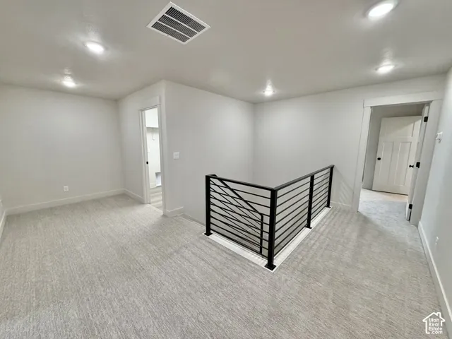 Interior area featuring recessed lighting, wall-to-wall carpeting, and a black metal horizontal-bar railing