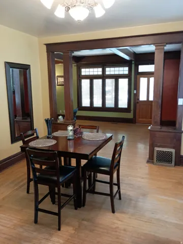Hardwood flooring throughout, decorative ceiling light fixture, and classic wood trim