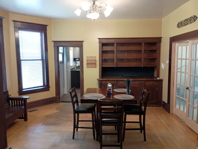 Wood-finish flooring throughout, featuring a built-in wooden hutch with shelving and cabinetry